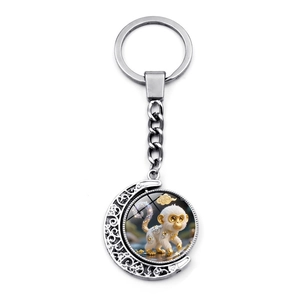 Detail of silver zodiac keychain featuring a rotating moon pendant with a monkey motif