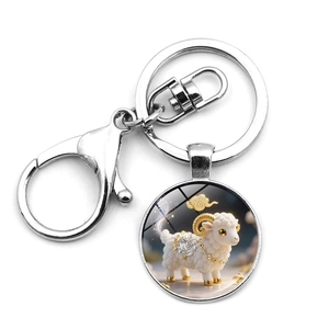 Detail of silver metal keychain with round glass pendant featuring a cute ram illustration