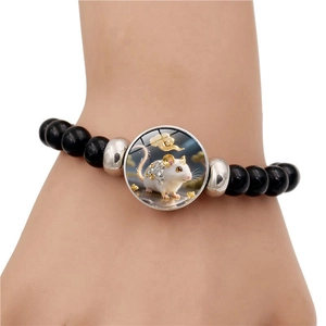 Gros plan du bracelet en perles noires avec breloque en verre rat du zodiaque et nuage