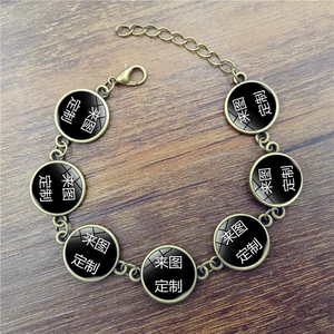 Vintage bronze custom bracelet with multiple round glass pendants on a wood background