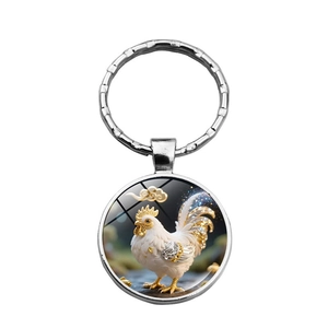 Détail du porte-clés en métal argenté avec pendentif en verre motif coq et nuages