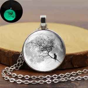 Luminous bat necklace detail showing cat and moon art with green glow effect