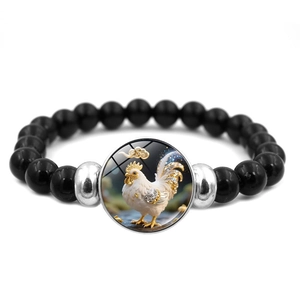 Détail d'un bracelet en perles noires avec un charme de coq du zodiaque et des accents
