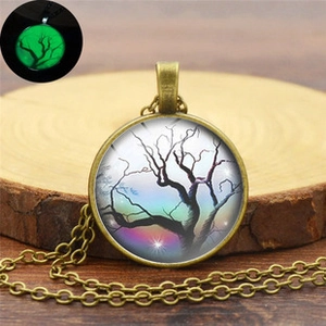 Detailed view of a glowing tree of life pendant with luminous green effect in the dark