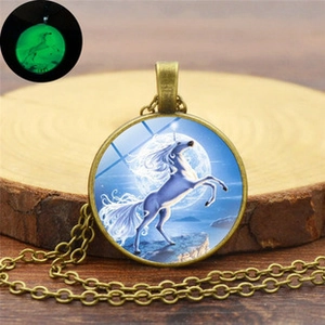 Luminous unicorn pendant necklace with bronze chain shown in dark and light settings