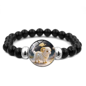 Gros plan du bracelet en perles noires avec breloque en verre signe du zodiaque mouton