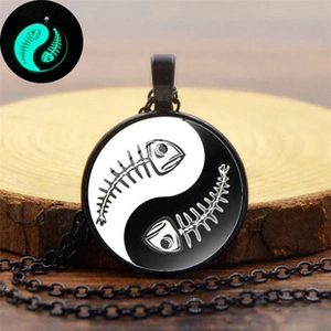Gothic round bat necklace showing green glow effect in the dark on wood surface