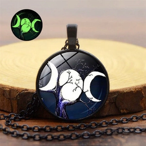 Macro shot of luminous bat necklace featuring triple moon goddess glow in the dark pendant