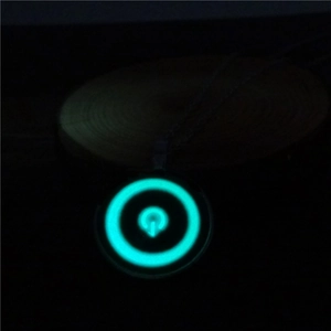Detail van de lichtgevende aan/uit-knop hanger ketting in een donkere omgeving