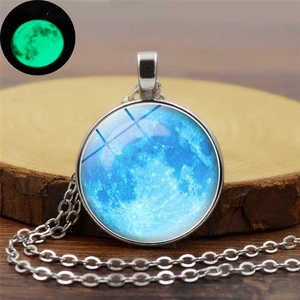 Vue détaillée du collier planète avec pendentif lune bleue et effet lumineux vert dans le noir