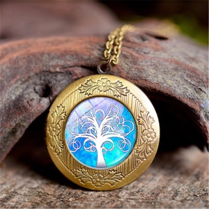 Detail of vintage Tree of Life locket necklace with bronze floral engraving on wood