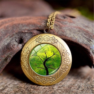 Macro view of vintage bronze tree of life locket with floral relief on wood background