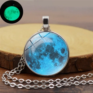 Collier pendentif lune lumineuse avec effet phosphorescent sur fond de bois rustique