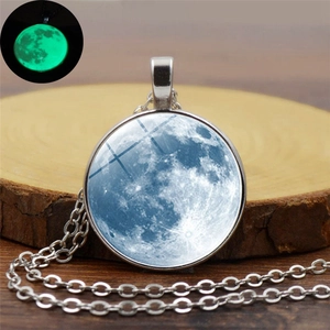 Vue macro détaillée montrant le pendentif lune brillant en vert dans l'obscurité