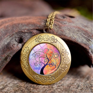 Macro shot of bronze Tree of Life locket necklace with colorful art on wood bark