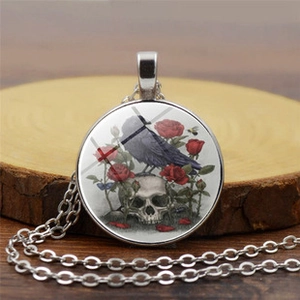 Dettaglio della collana vintage con ciondolo gotico corvo, teschio e rose rosse