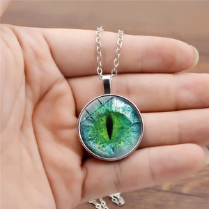 Dettaglio ravvicinato della collana con ciondolo occhio di drago verde e catena d'argento