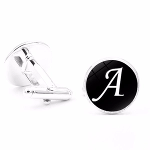 Close-up of silver men cufflinks with black round inlay and white letter A detail
