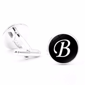 Close-up of polished silver cufflinks with black background and white letter B design