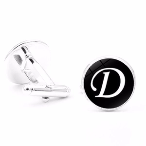 Detailed close-up of silver men's cufflinks with black circle and white letter D