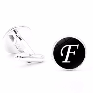 Detail view of silver round cufflinks featuring letter F with bullet back closure