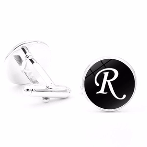 Detailed close-up of men's silver cufflinks with letter R on a black background