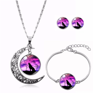 Detailed set of silver howling wolf moon jewelry featuring a necklace, bracelet and earrings