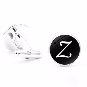 Macro detail of silver cufflinks with black base and white letter Z engraved pattern