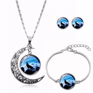 Three-piece jewelry set detail featuring howling wolf glass cabochon pendants