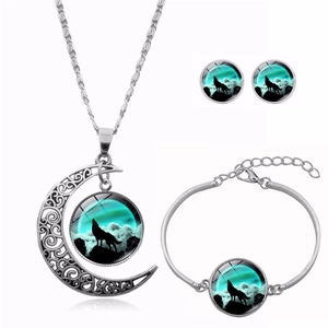 Detail of howling wolf moon jewelry set featuring glass dome necklace, bracelet and earrings