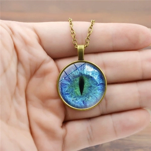 Handheld vintage bronze necklace with a glowing blue dragon eye glass gem pendant