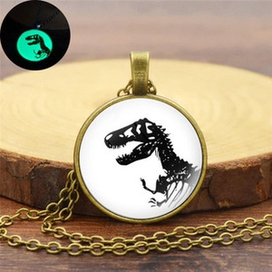 Détail du collier vintage en bronze avec crâne de dinosaure et effet de lueur nocturne