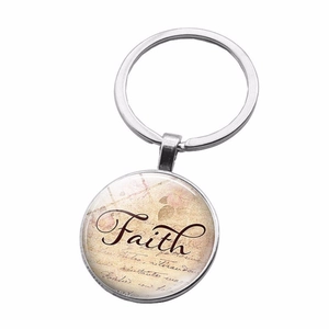 Detailed macro view of silver Faith keychain with vintage floral lettering and glass dome