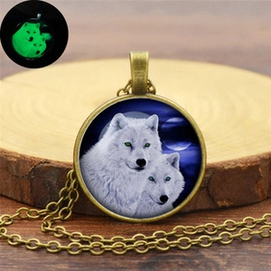 Détail du collier pendentif loup en bronze avec effet lumineux vert dans le noir