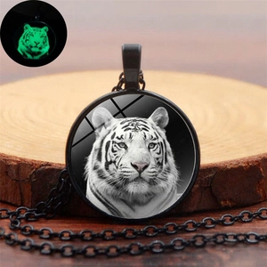 Luminous white tiger glass pendant necklace with green glow effect on dark metal chain