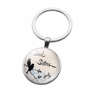 Close-up of Soul Sisters engraving with two birds on a silver metal round keychain