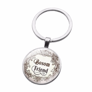 Detailed close-up of a silver Bosom Friend glass cabochon keychain with vintage borders