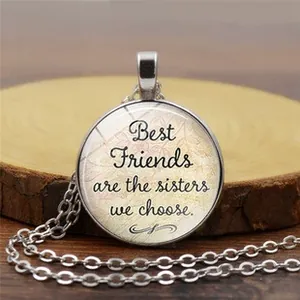 Détail macro du pendentif rond en verre avec citation Best Friends et chaîne argent