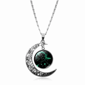 Dettaglio di una collana a mezza luna d'argento con un ciondolo in vetro del Sagittario