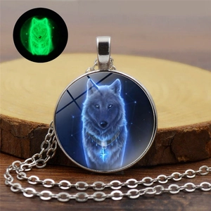 Glow-in-the-dark wolf head pendant with green luminous effect on wood background