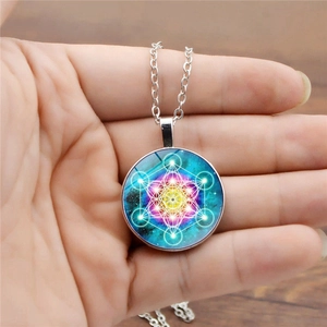 Détail du collier mandala avec le cube de Métatron blanc sur un fond de nébuleuse colorée