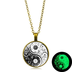 Luminous Yin Yang necklace with floral bronze pendant showing green glow in the dark