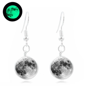 Detail showing lunar print earrings with luminous green glow effect in the dark