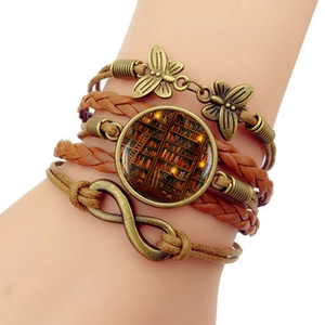 Détail du bracelet multicouche en cuir bohème avec signe infini et motif bibliothèque