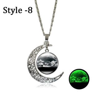 Detail of silver moon pendant necklace showing luminous green glow in dark