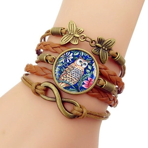 Détail du bracelet bohème multicouche en cuir avec symbole infini et breloque hibou