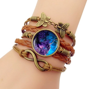 Detail of multi-layer woven bracelet with dragonfly butterfly and infinity charms