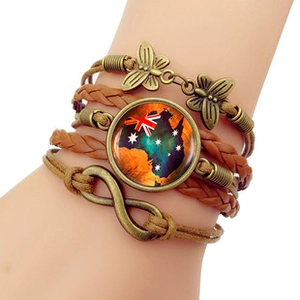 Detail of layered leather bracelet with Australia map charm and infinity metal charms