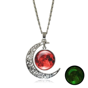 Detailed view of silver moon pendant with red stellar cabochon and green glow-in-the-dark effect