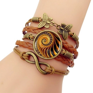 Close-up of bohemian layered leather bracelet with bronze infinity and butterfly charms